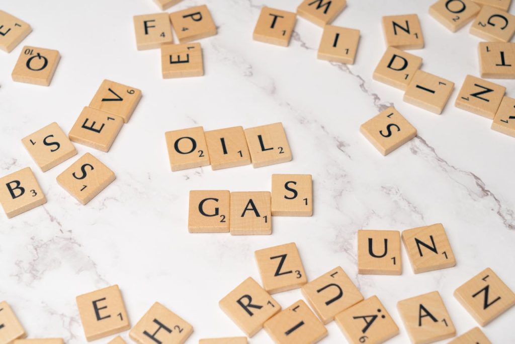 Scrabble tiles on marble spelling oil and gas, concept for energy and creativity.